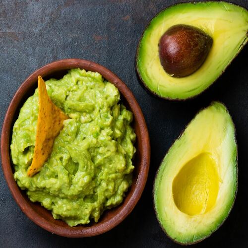 Latin American sauce guacamole and avocado sandwiches on dark background.